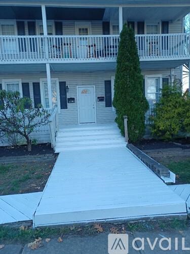 A white building with a white door and a white railing.