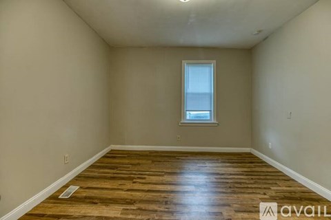 A room with wooden flooring and a window.
