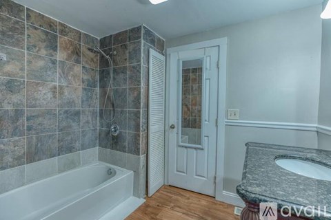 A bathroom with a marble countertop and a walk-in shower.