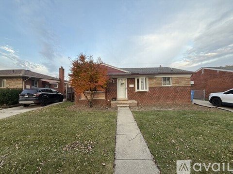 A house with a tree in front and a car parked in the driveway.