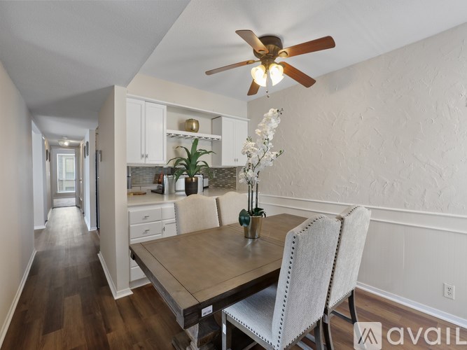A dining room with a table and chairs and a ceiling fan.