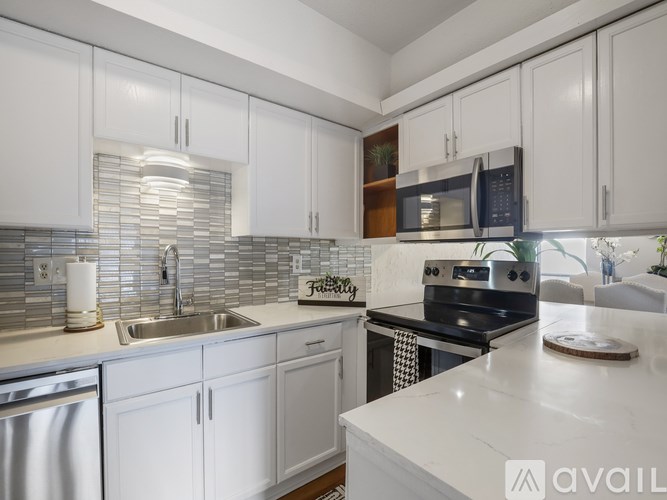 A kitchen with white cabinets and a stainless steel dishwasher.
