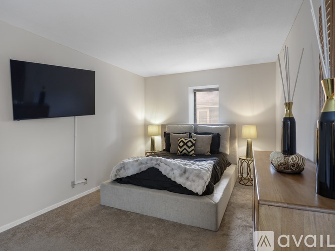 A modern bedroom with a large bed and a flat screen TV mounted on the wall.