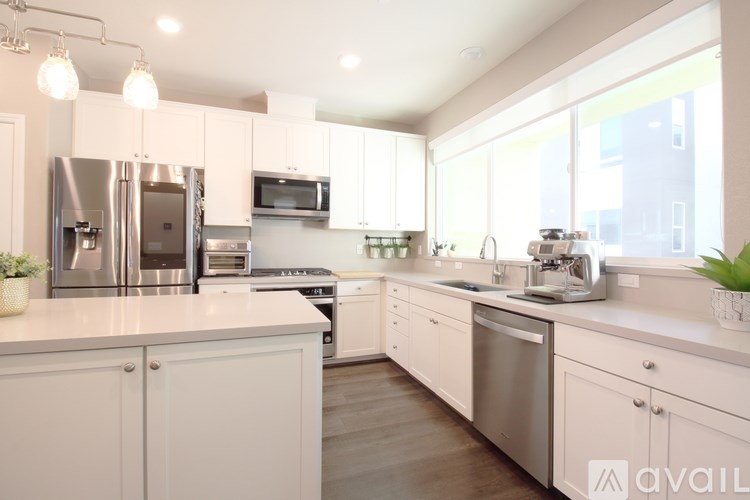 A modern kitchen with white cabinets and stainless steel appliances.