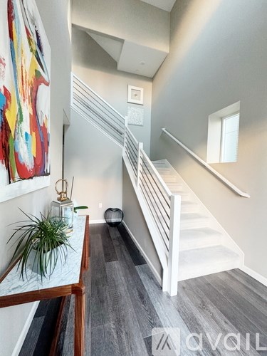 A staircase with a white railing and a potted plant on the landing.