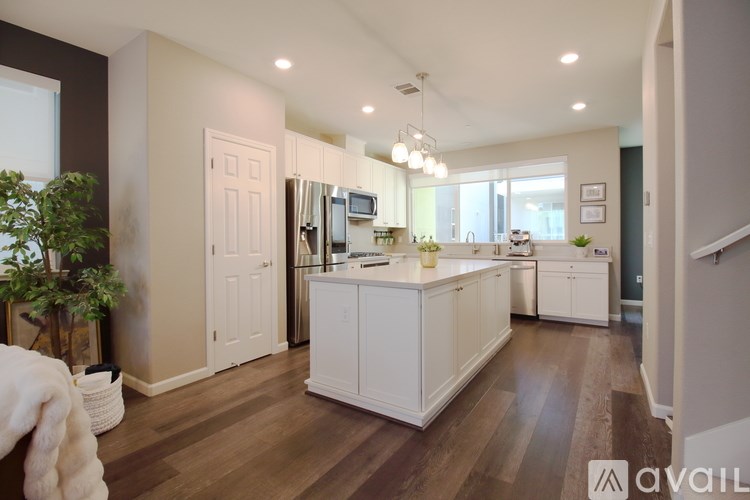 A kitchen with white cabinets and a wooden floor.