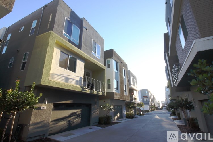 A row of modern townhouses with balconies and garages.