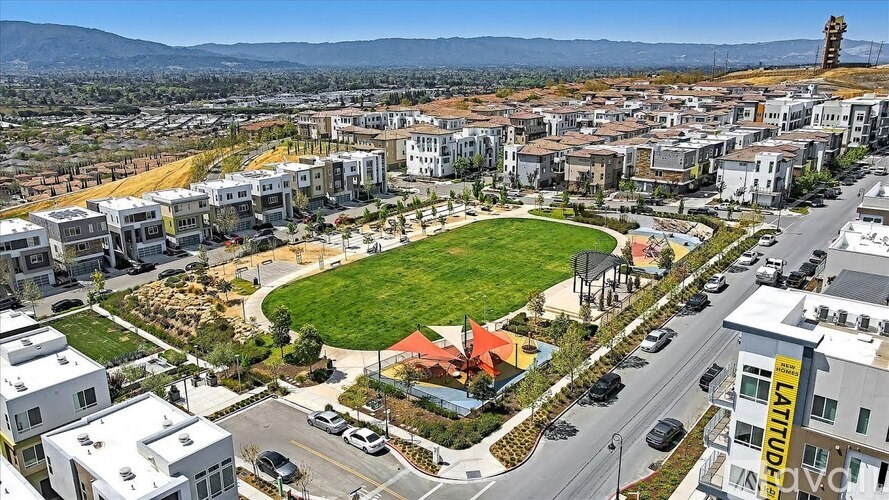 A cityscape with a large green field in the center and buildings surrounding it.