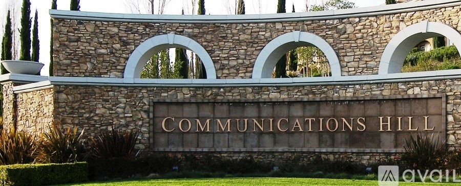 A stone wall with the words "Communications Hill" engraved on it.