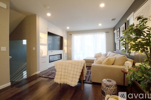 A modern living room with a white sofa and a wooden floor.