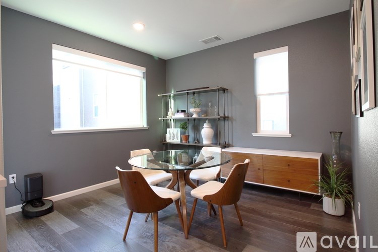 A modern dining room with a glass table and chairs.