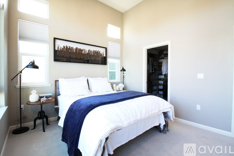 A bedroom with a large bed and a painting on the wall.