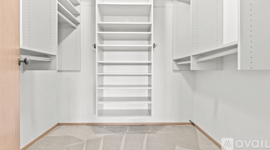 A white interior with a staircase and a door.