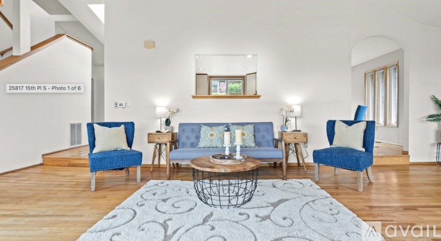A living room with blue chairs and a white wall.