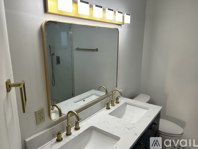 A bathroom with a marble counter top and a large mirror.