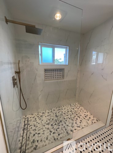 A shower with a glass door and a window.