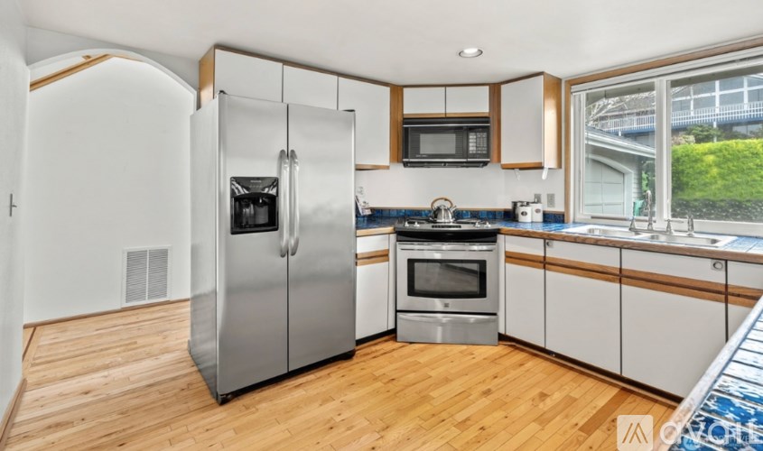 A kitchen with a refrigerator, oven, and microwave.