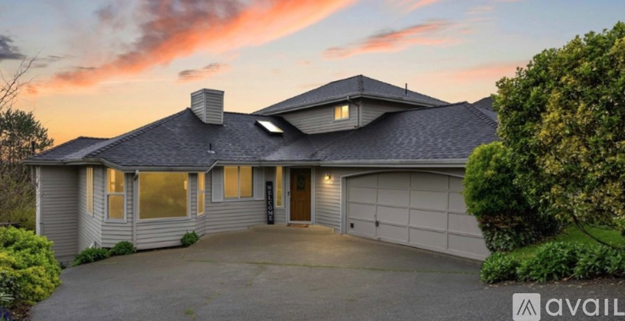 A house with a grey roof and a garage is available for sale.