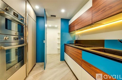 A modern kitchen with a stainless steel refrigerator and wooden cabinets.