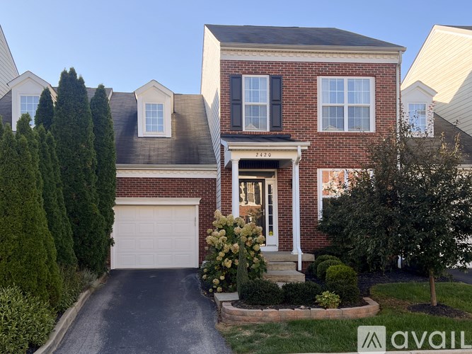 A house with a brick facade and a white garage door is for sale.