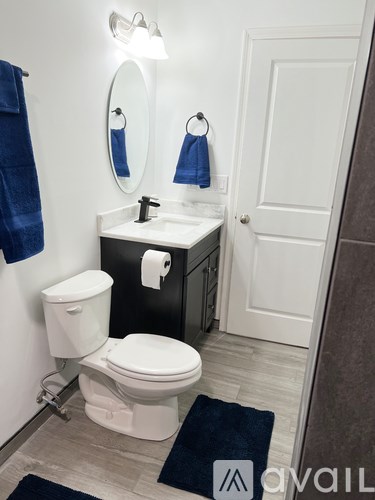 A white toilet with a white sink and a mirror above it.