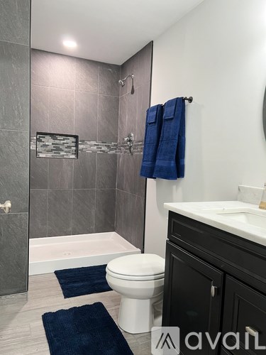 A bathroom with a toilet, sink, and shower.