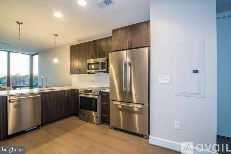 A kitchen with stainless steel appliances and wooden cabinets.