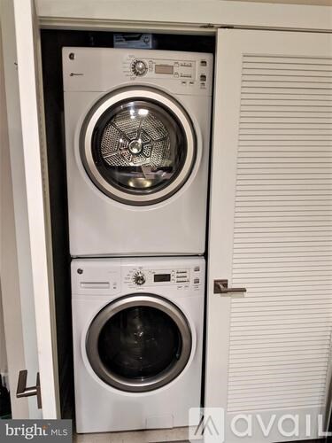 Two white front loading washing machines in a small room.