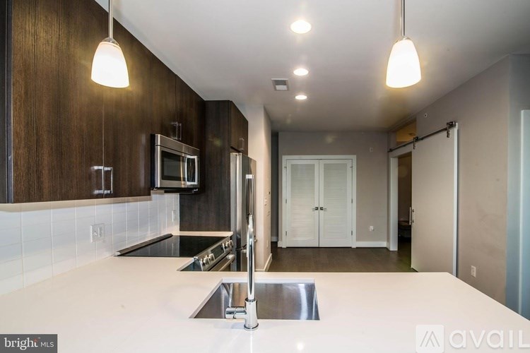 A modern kitchen with a stainless steel sink and wooden cabinets.