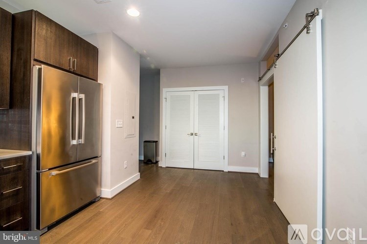 A kitchen with a stainless steel refrigerator and wooden cabinets.