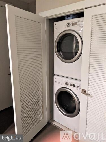 A washing machine is sitting in a cabinet.