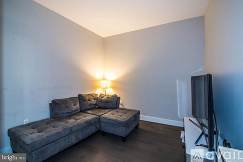 A living room with a grey couch and a television.