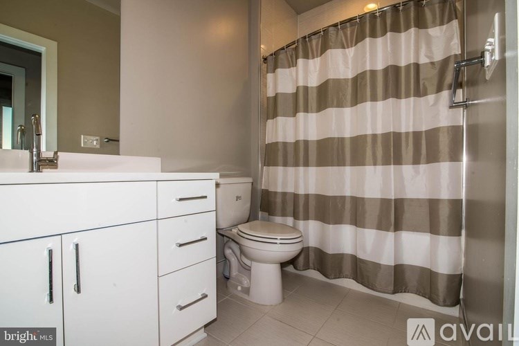 A bathroom with a toilet, sink, and shower curtain.