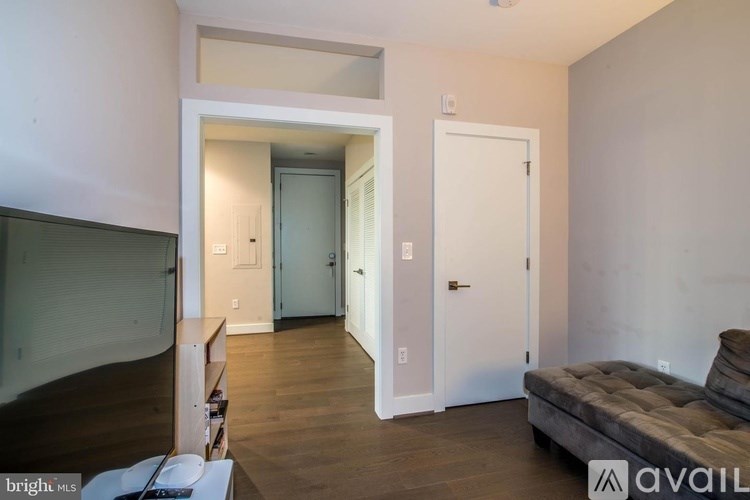 A living room with a grey couch and a white door.