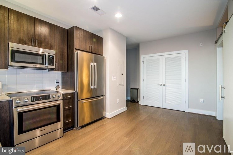 A kitchen with stainless steel appliances and wooden cabinets.