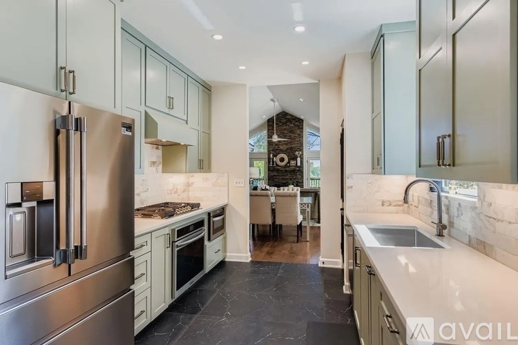 A modern kitchen with stainless steel appliances and a marble countertop.
