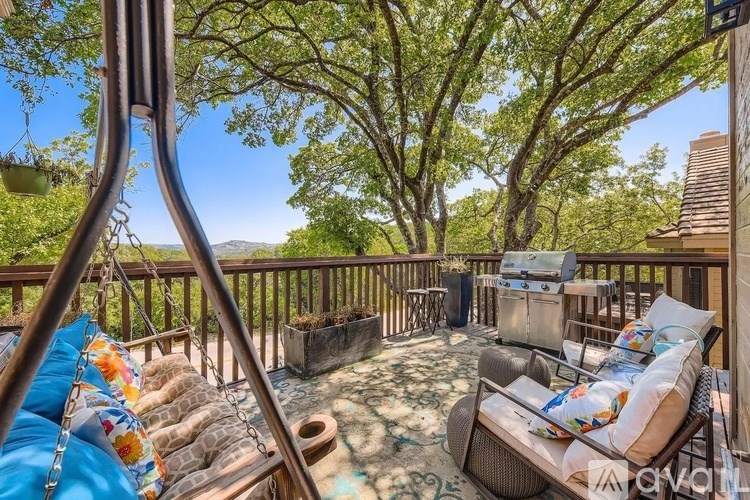 A porch with a swing and a table with chairs.