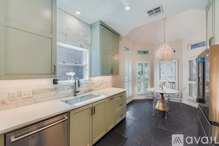 A kitchen with a marble backsplash and a dining table with chairs.