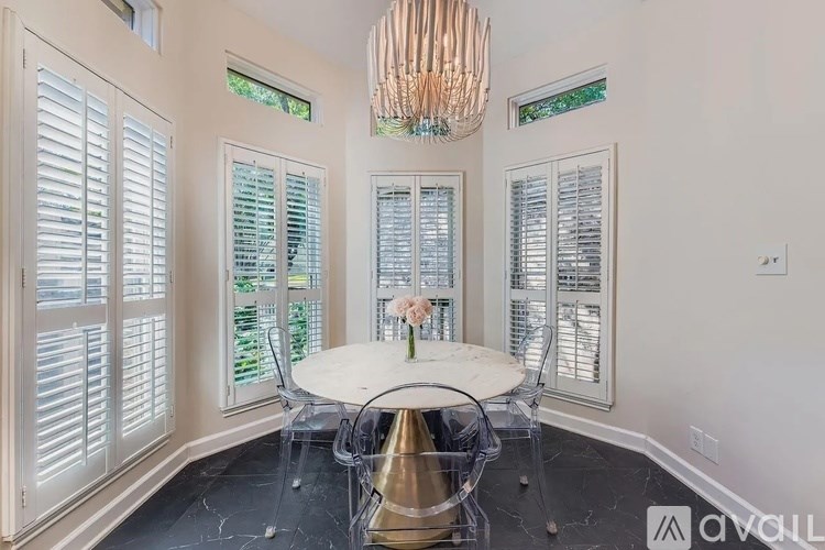 A dining room with a round table and chairs.