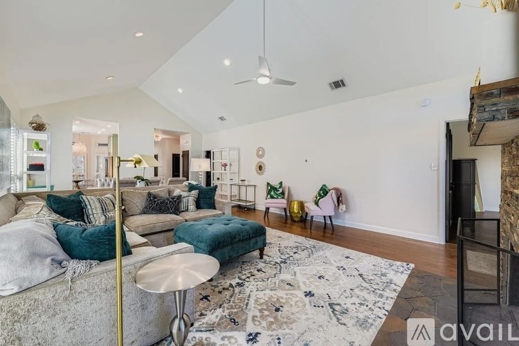 A living room with a grey couch and a rug.