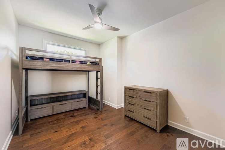 A room with a bunk bed and a dresser.