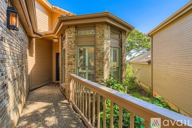 A house with a balcony and a brick wall.