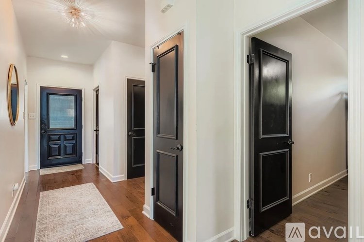 A hallway with a rug and two doors.