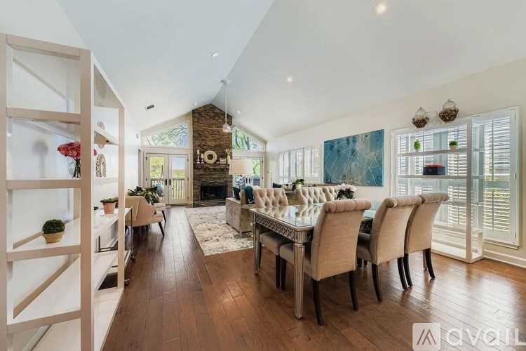 A dining room with a large table and chairs.