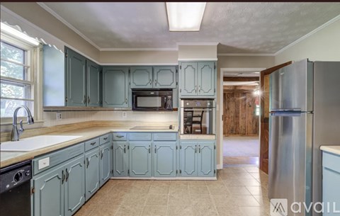 A kitchen with blue cabinets and a stainless steel refrigerator.