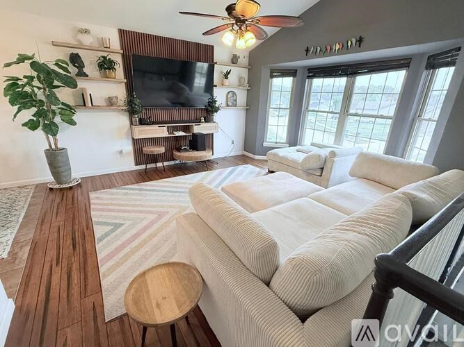 A living room with a white couch and a wooden floor.