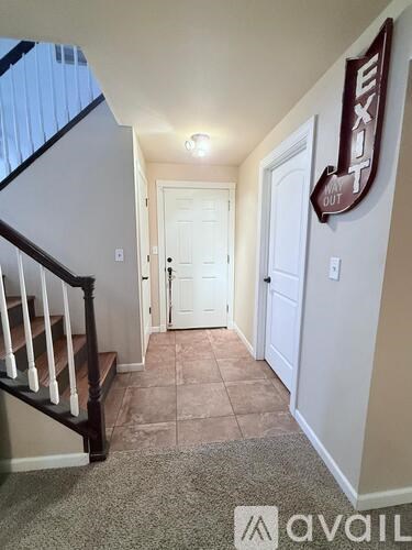 A hallway with a white door and a brown exit sign.