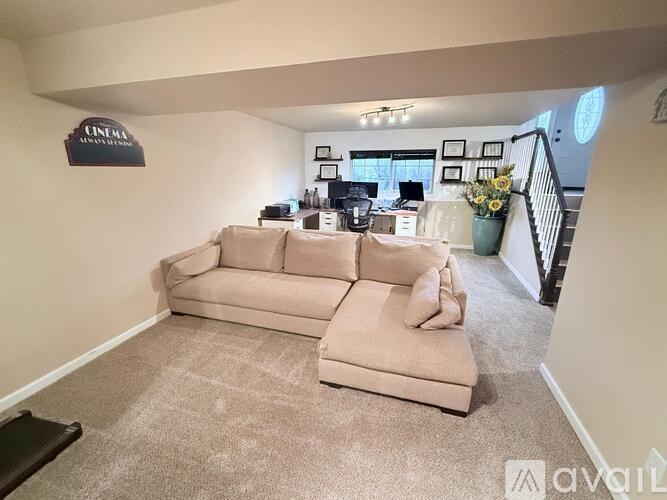 A living room with a couch and a sign on the wall.