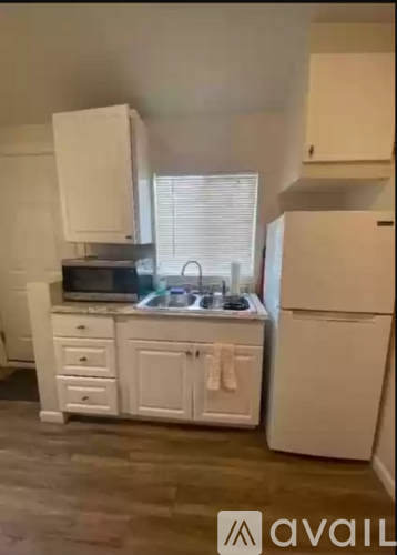 A kitchen with white appliances and cabinets.