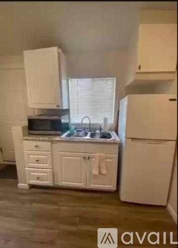 A kitchen with white appliances and cabinets.